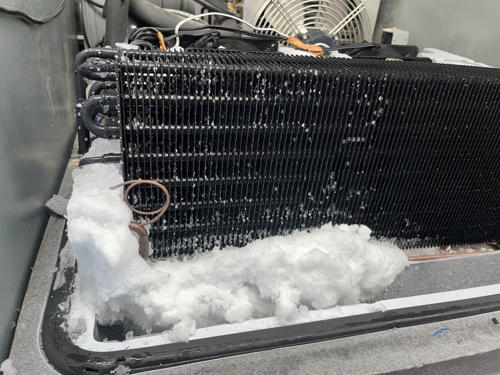 Gradual ice build-up around a freezer cabinet air grille