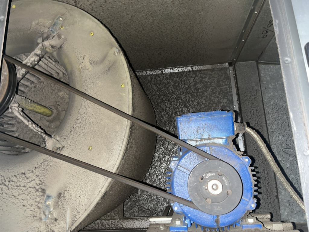 Ventilation fan, motor and belt drive covered in heavy dust